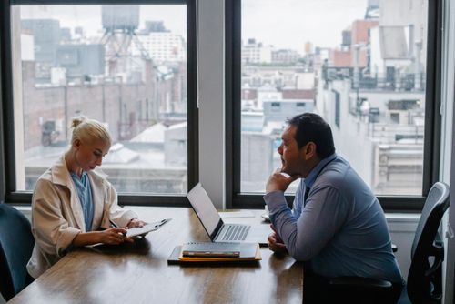 Free Business meeting between colleagues in a modern office setting with city view. Stock Photo