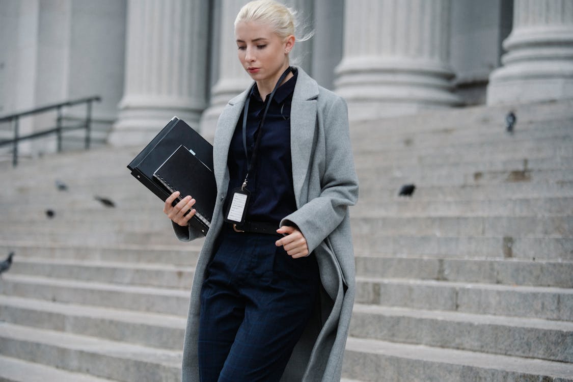 Free Serious businesswoman hurrying with documents from courthouse Stock Photo