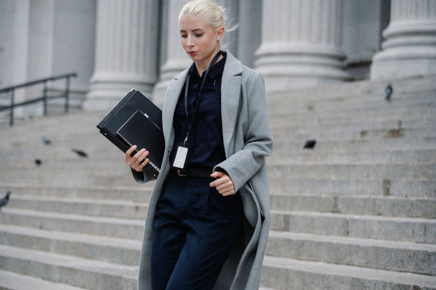 Researcher carrying documents outside a courthouse