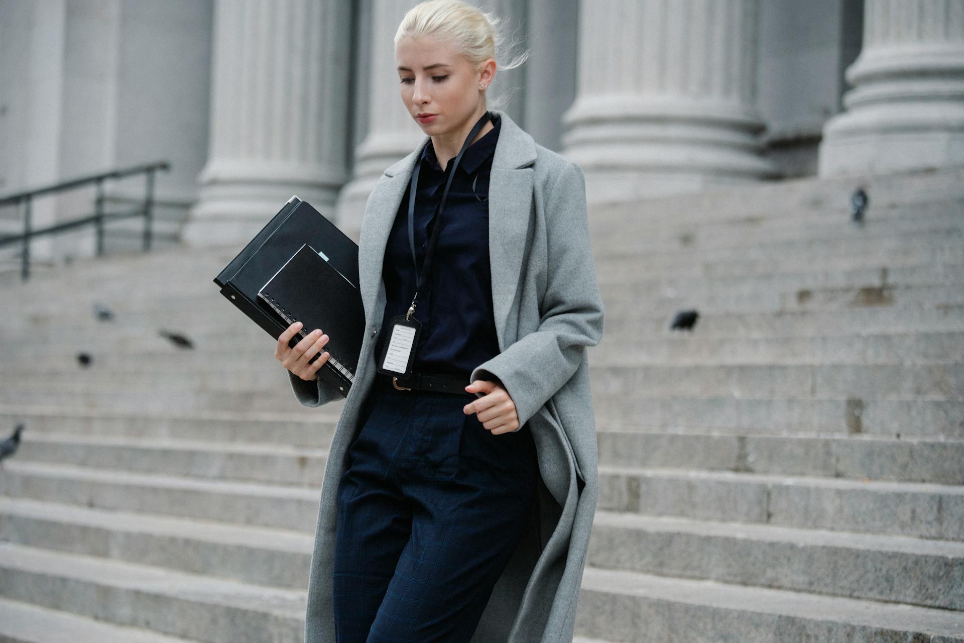 Serious businesswoman hurrying with documents from courthouse