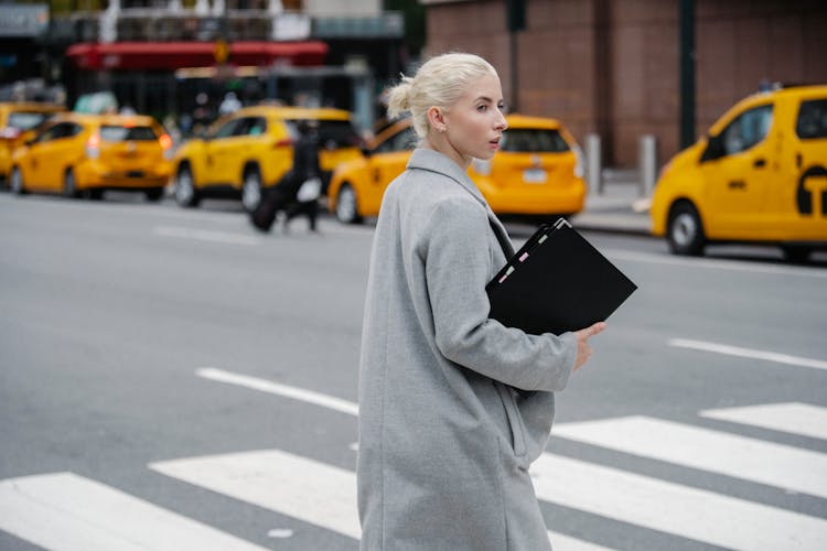 Female Office Worker With Folder Crossing City Road