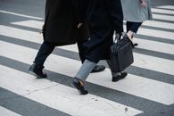 匿名商业人士在城市人行横道上行走，展现动感与城市生活