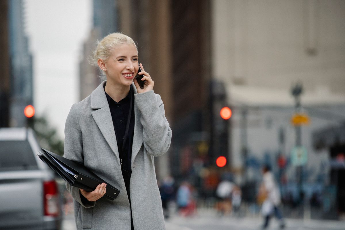 Woman making a confident phone call on a city street