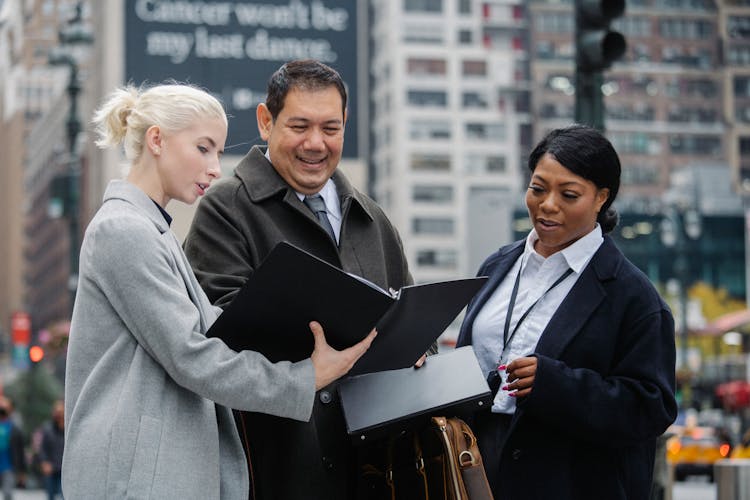 Multiethnic Office Workers Discussing Project On City Street