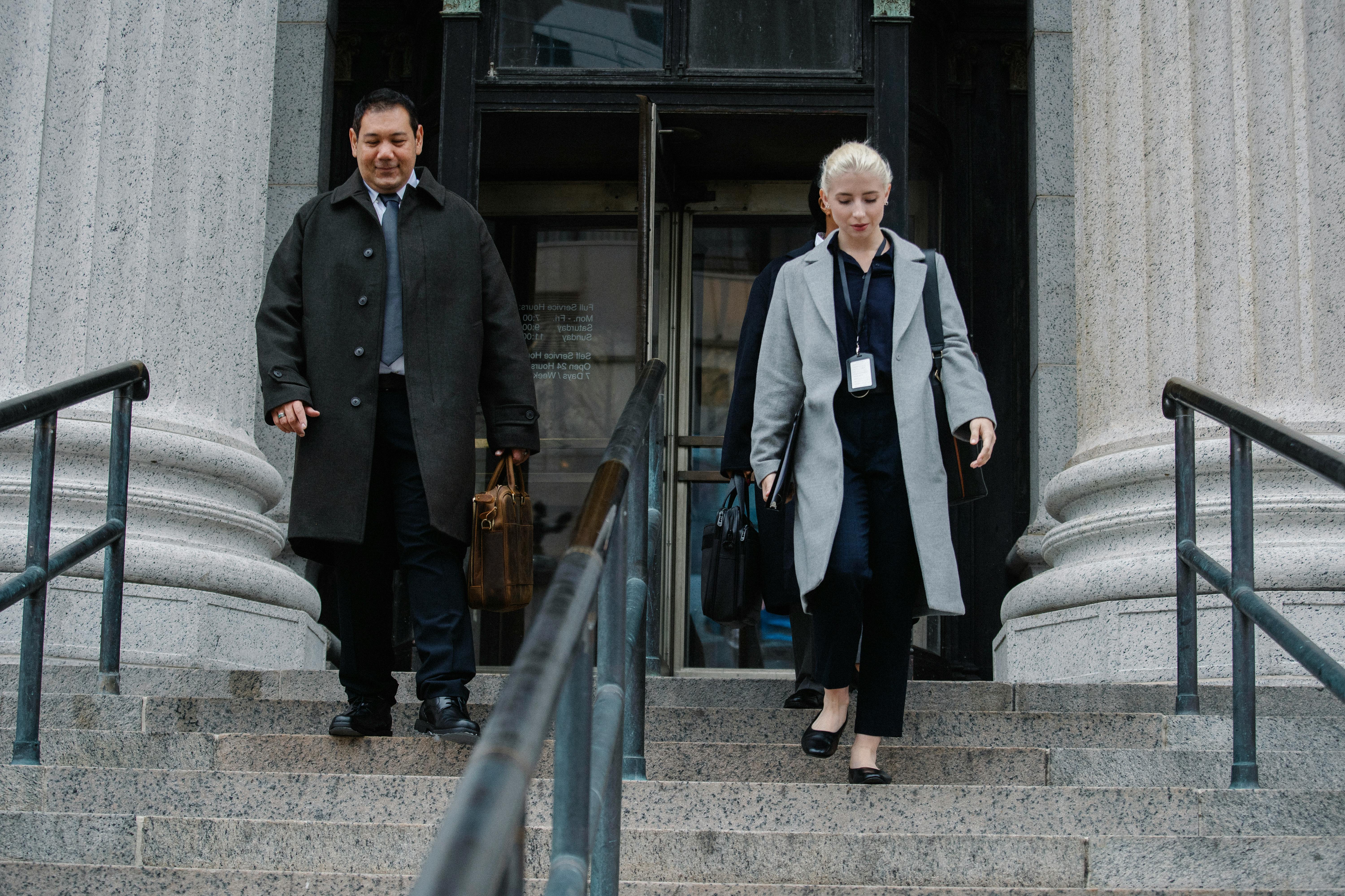 multiracial office workers going down stairs on street