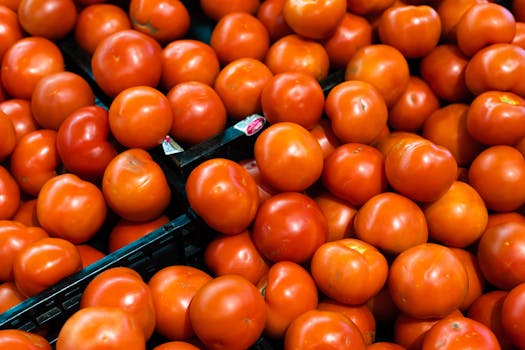 Close-up of fresh red tomatoes on grocery store shelves, showcasing vibrant color and texture.