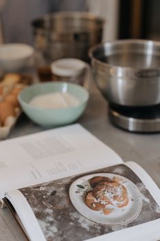 An inviting scene with a cookbook and baking ingredients in a kitchen setting, perfect for culinary inspiration.