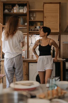 Two women enjoying a casual conversation in a cozy kitchen setting, adding warmth to the home atmosphere.