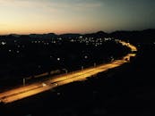 在印度拉贾斯坦邦苏赫尔，一条明亮的高速公路在宁静的夜色中延伸，背景是山脉