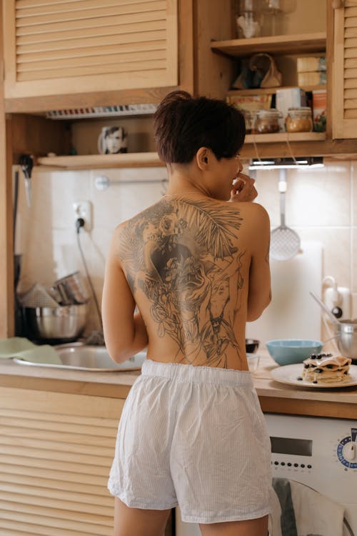 Back View of a Topless Person Wearing White Shorts in the Kitchen