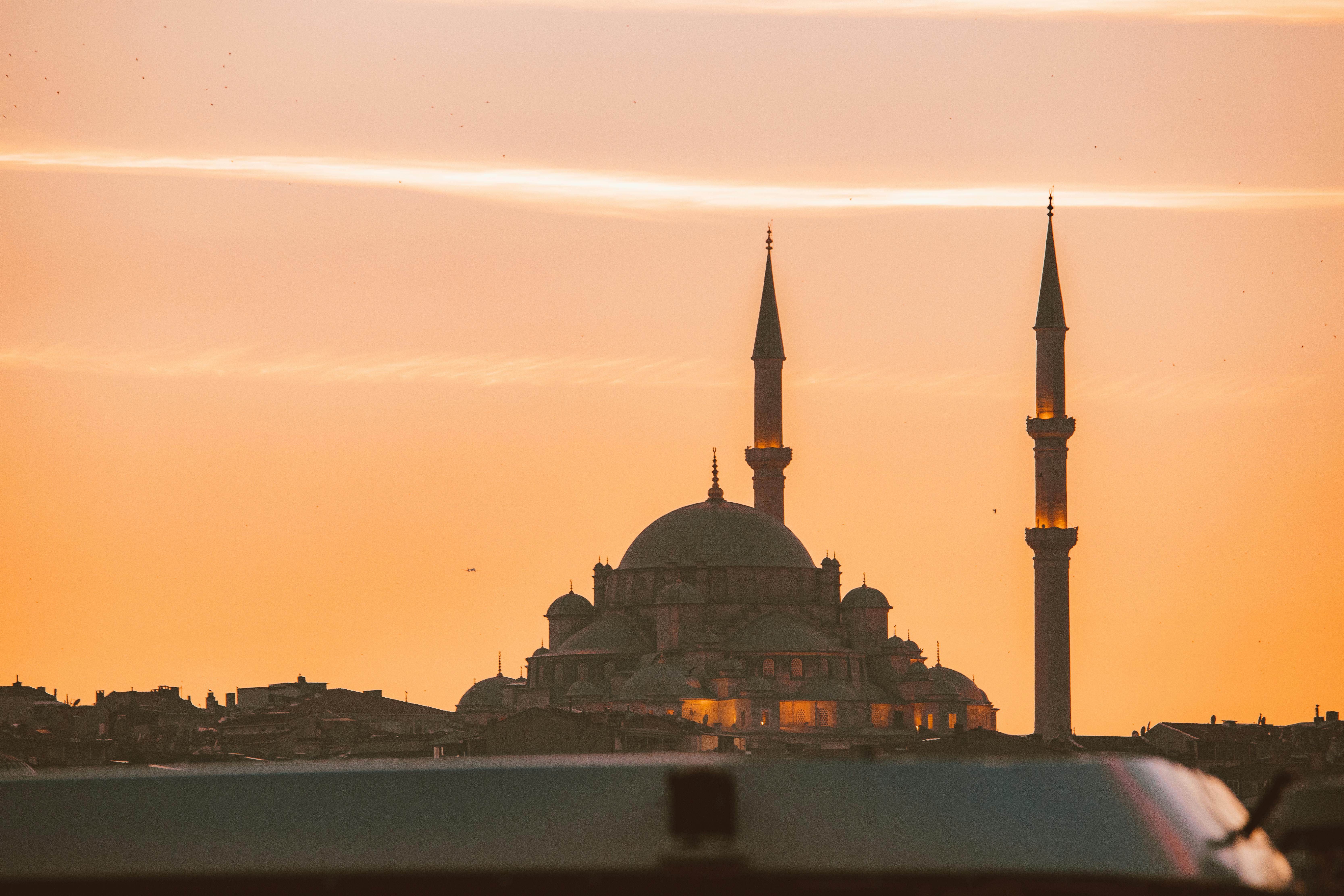 mosque with minarets against orange sky