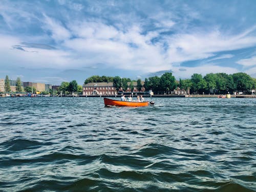 Orange Boat on Body of Water