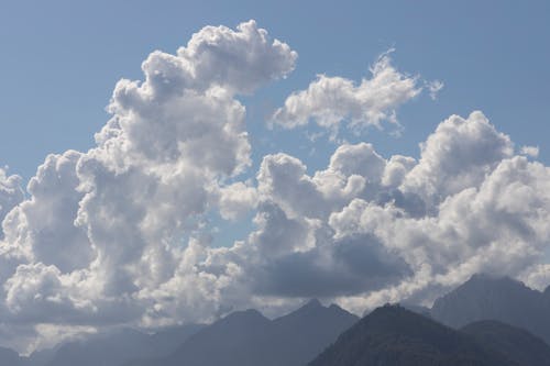Free White Fluffy Clouds over Mountains Stock Photo