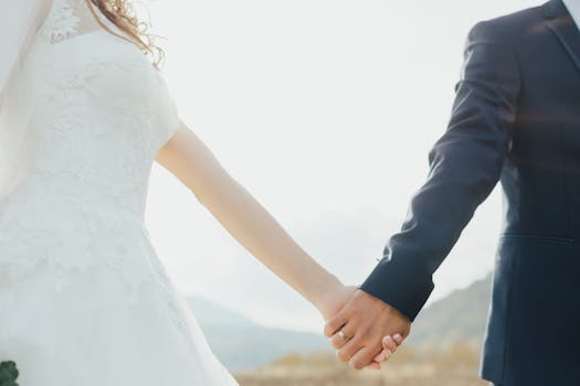 Bride and groom holding hands in a romantic outdoor setting, symbolizing love and unity.