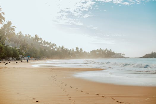Footprints in the sand on a tranquil beach in Mirissa, Sri Lanka at sunrise.