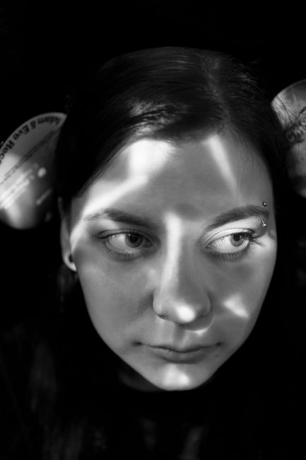 Black and white serene young lady looking away while relaxing at home on sunny day