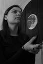 Concentrated young woman holding old vinyl record in hands