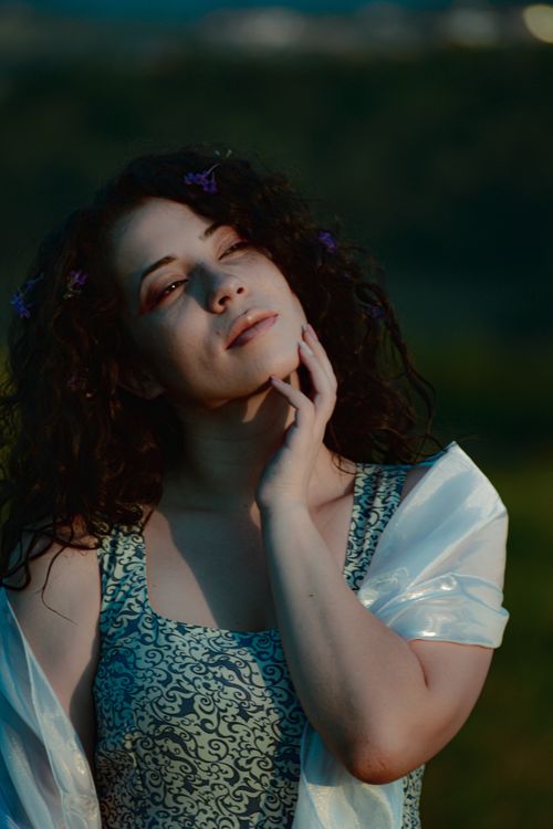 Free Young stylish female with makeup and tilted head looking up in twilight on blurred background Stock Photo