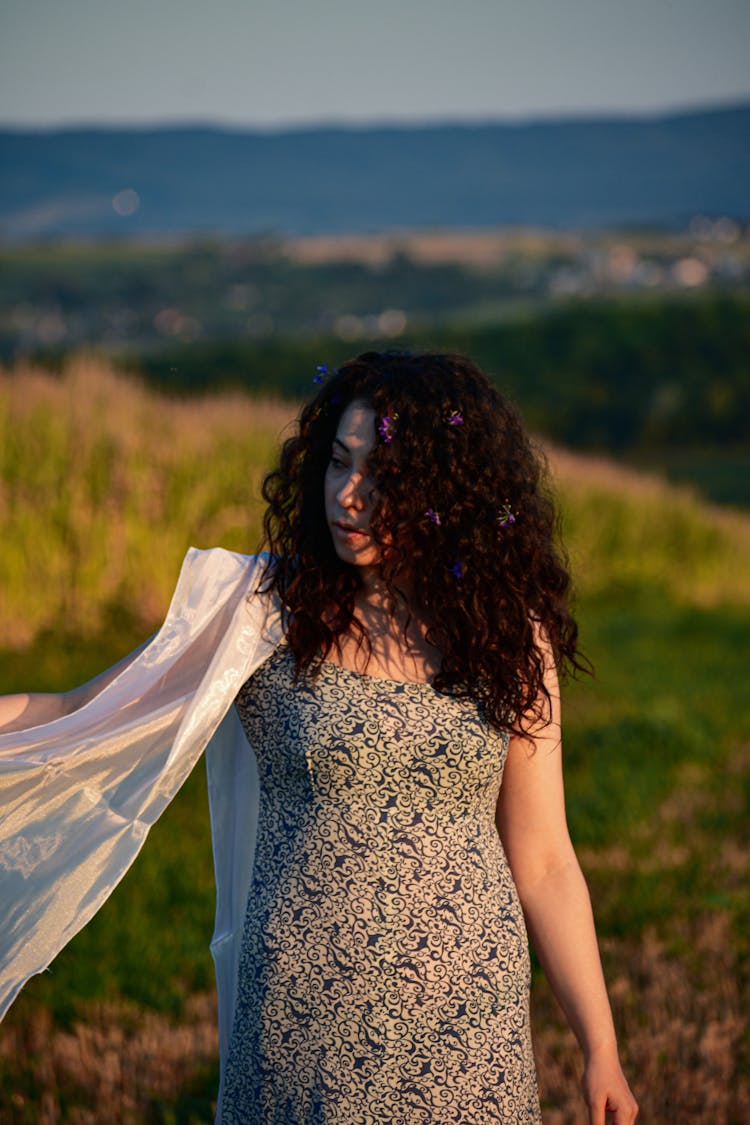 Elegant Woman With Flying Chiffon Scarf In Countryside Field