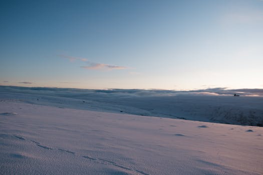 A tranquil snow-covered landscape in Troms og Finnmark during winter with soft lighting.