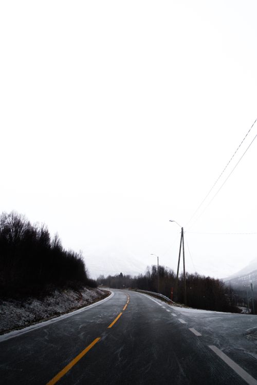 Free Empty road winding through snowy landscapes in Norwegen, perfect for winter travel themes. Stock Photo