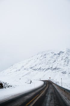 Snow-covered road winding through the winter landscape of Norway.