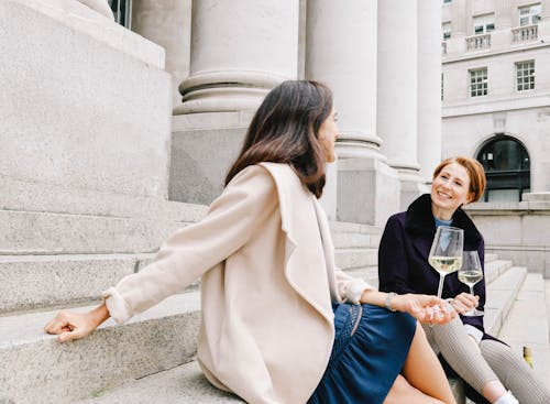 Happy Women drinking Wine on Staircase