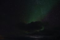 挪威上空的迷人星空景色中，隐约可见北极光
