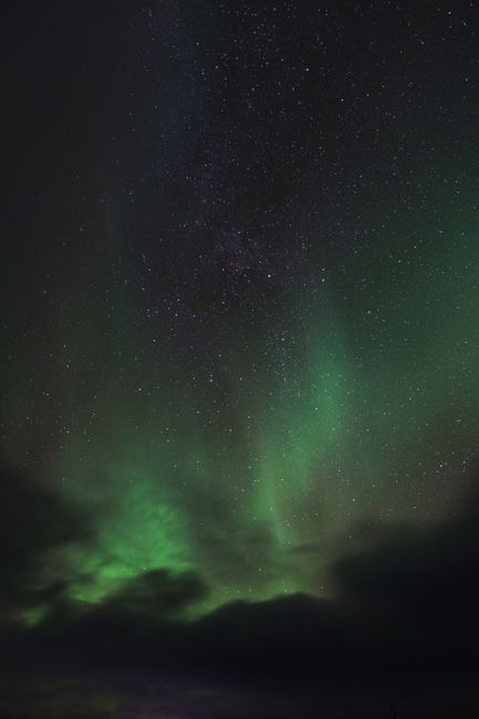 Capture of the Northern Lights illuminating a starry night sky over Norway.