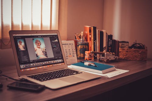 Free Turned on Screen Silver Macbook Air on Wooden Desk Stock Photo