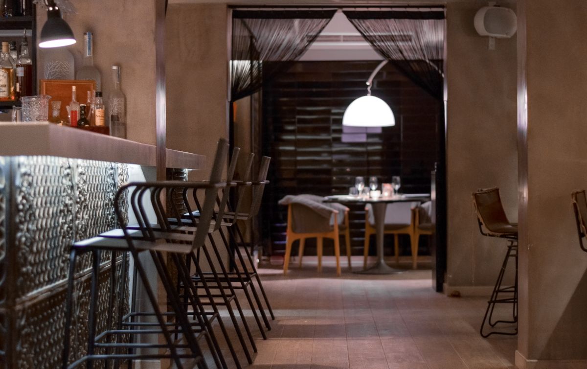 Bar stools along a warmly lit counter