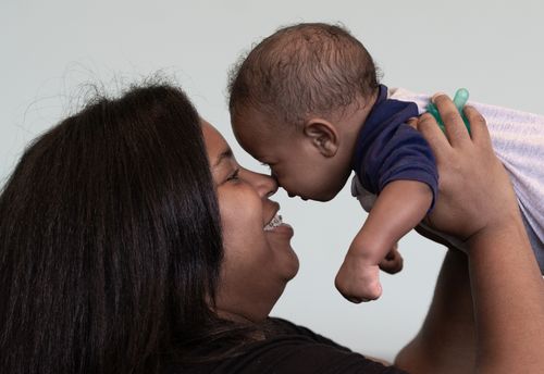 Free Heartwarming photo of a mother bonding with her baby, sharing a tender smile indoors. Stock Photo
