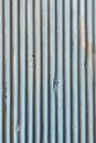 Background of old rusty metal wall with corrugated profile and relief texture with uneven gray surface and striped design outside