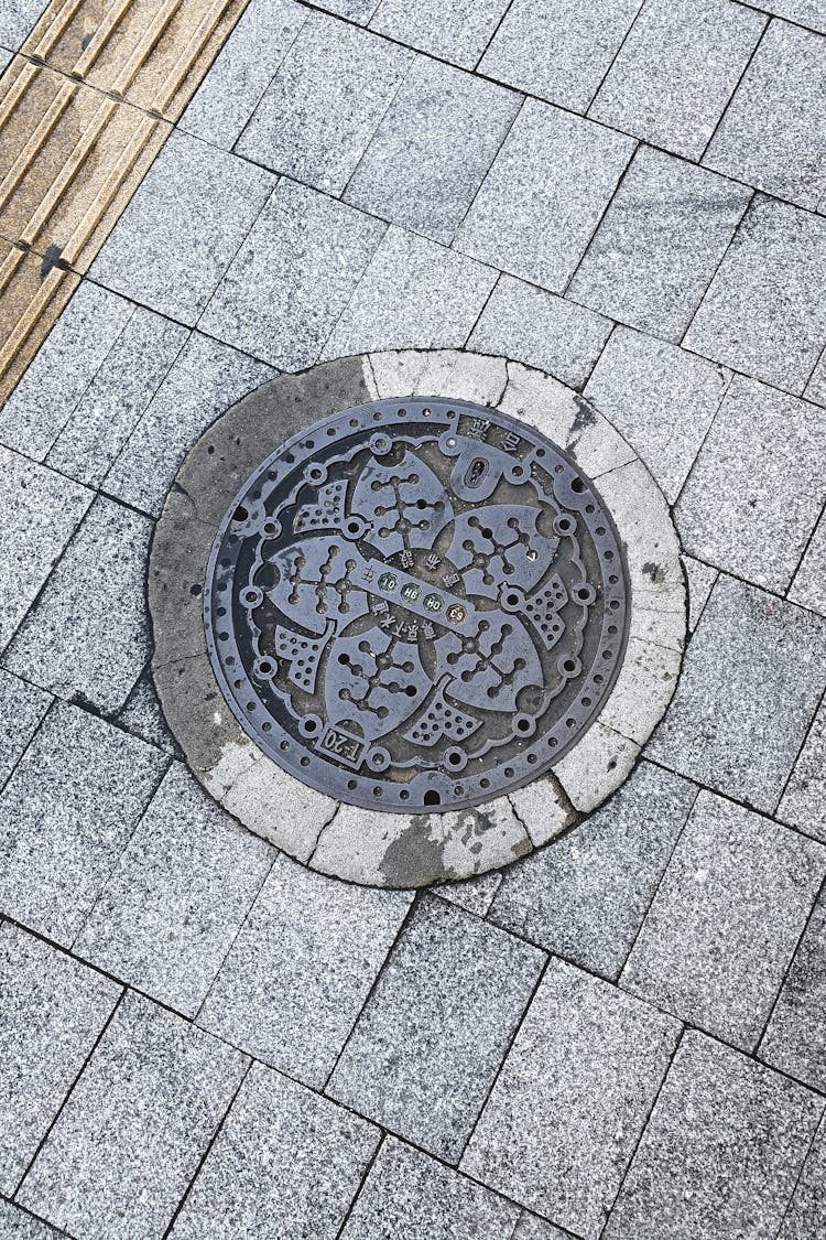 Manhole On Paving Stone In Street