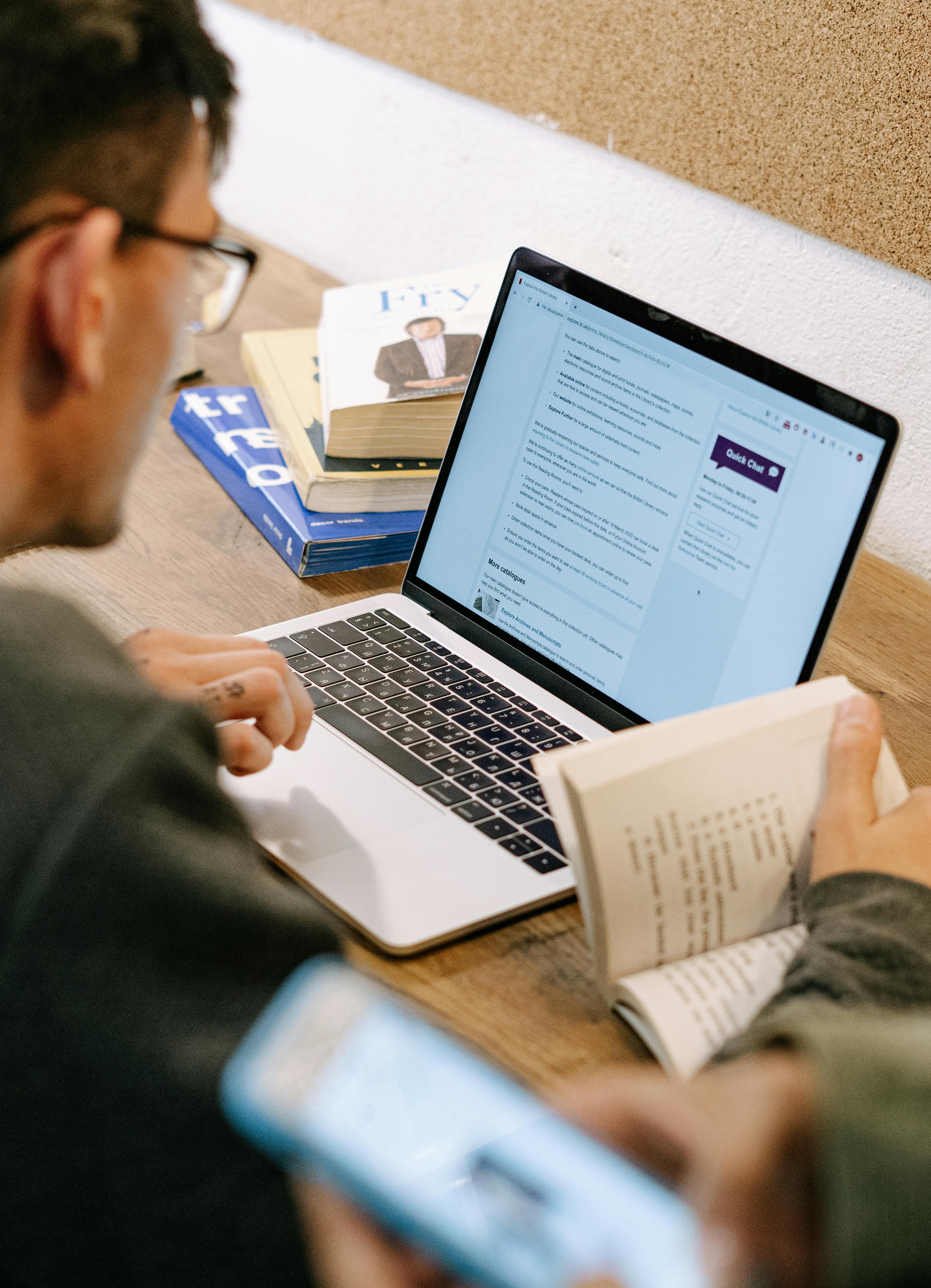 Man in Gray Sweater Using Macbook Pro