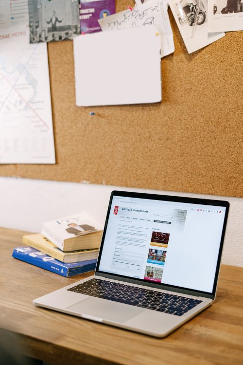 Free A laptop on a wooden desk at home, ideal for studying or remote work. Stock Photo