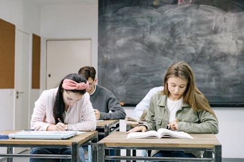 Students Sitting by the Table in the Classroom