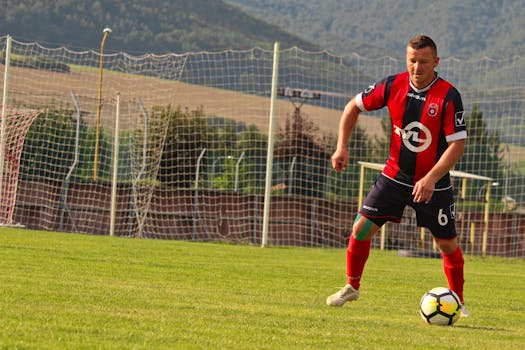 A soccer player in action on a sunny day at a field in Rajec, Slovakia.