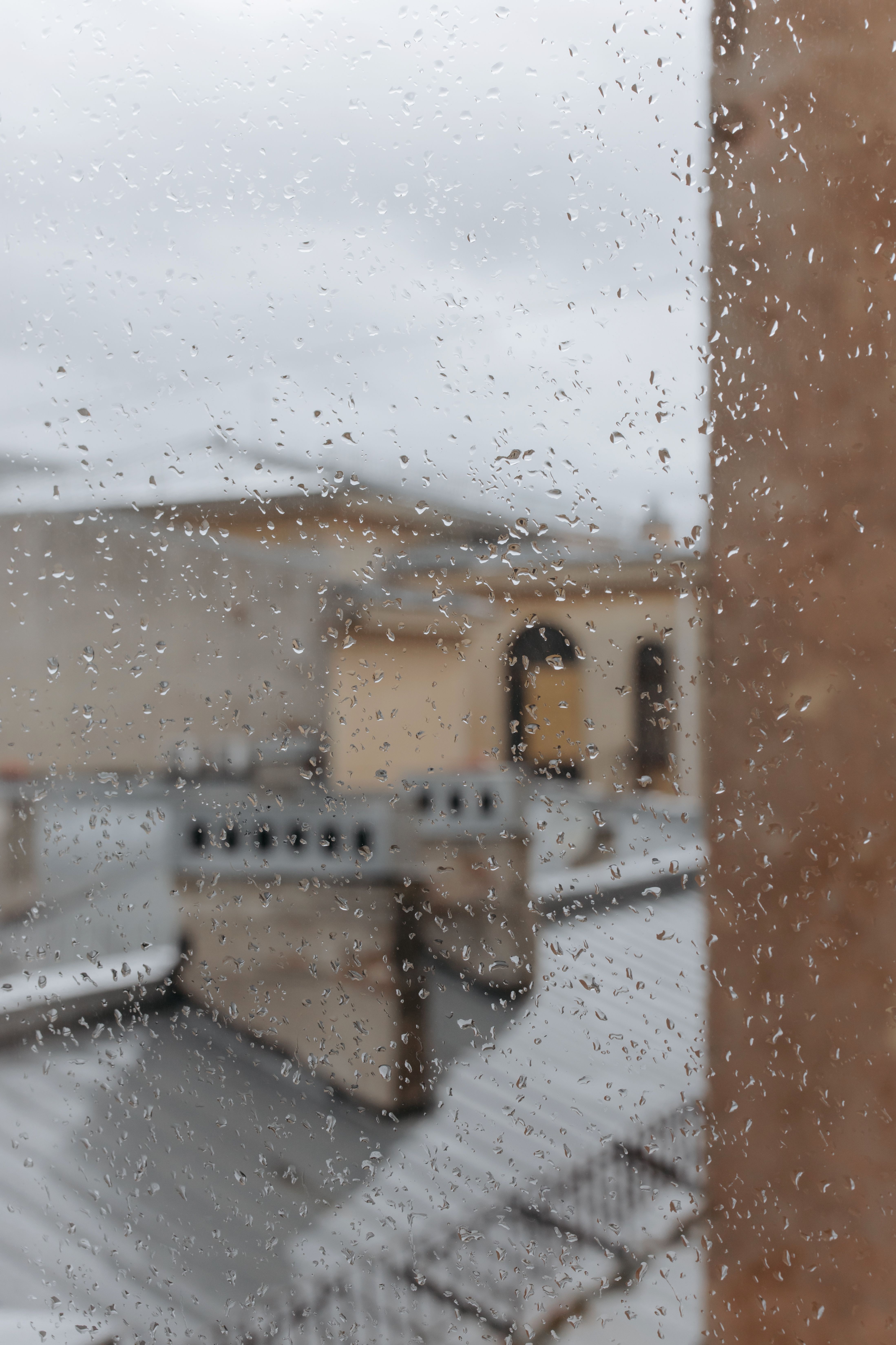 俯瞰城市屋顶，阴天窗户上的雨滴特写