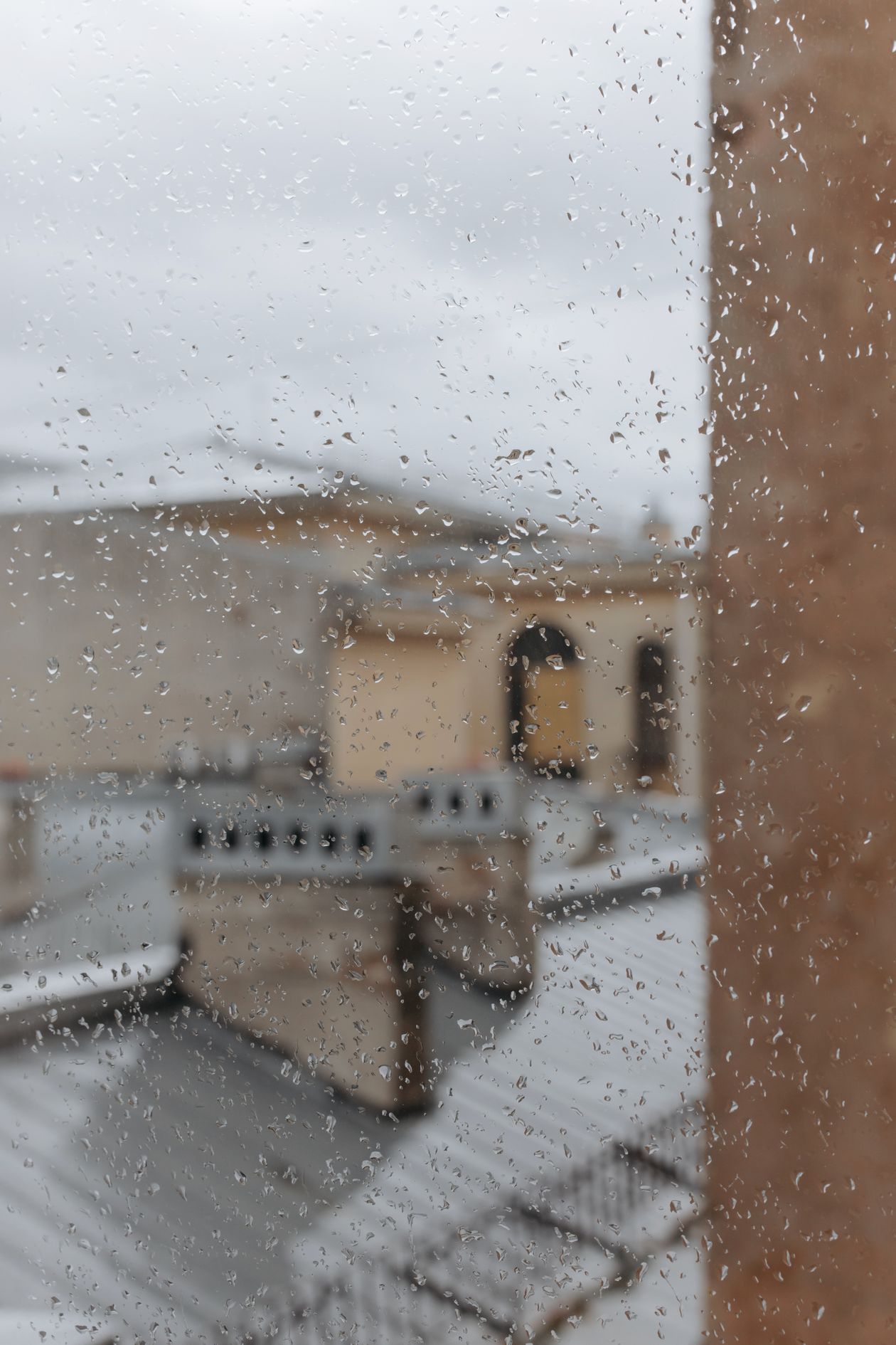 Raindrops on a window overlooking rooftops