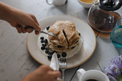 Free Woman Eating Pancakes with Blueberries  Stock Photo