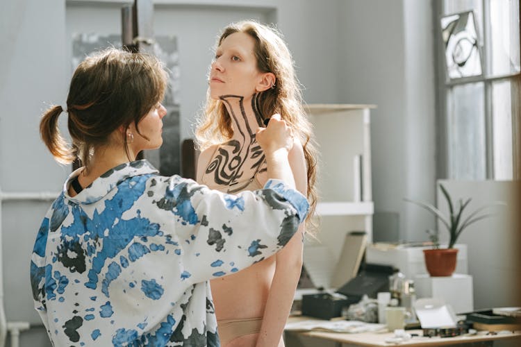 A Woman Painting Another Woman's Body