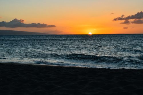 Free Picturesque scenery of sandy coast near rippling sea with waves and sundown in evening Stock Photo