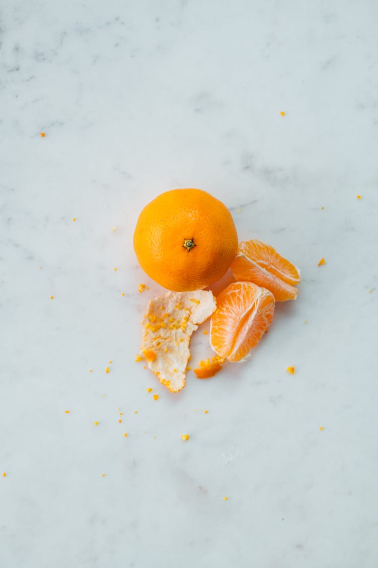 Slices Of Peeled Orange By Whole Fruit And Skin