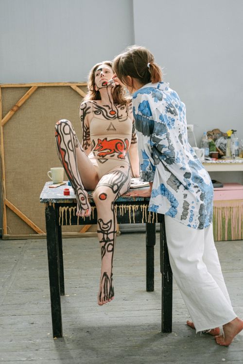 Free Artistic body painting session featuring intricate designs on a model, captured indoors. Stock Photo