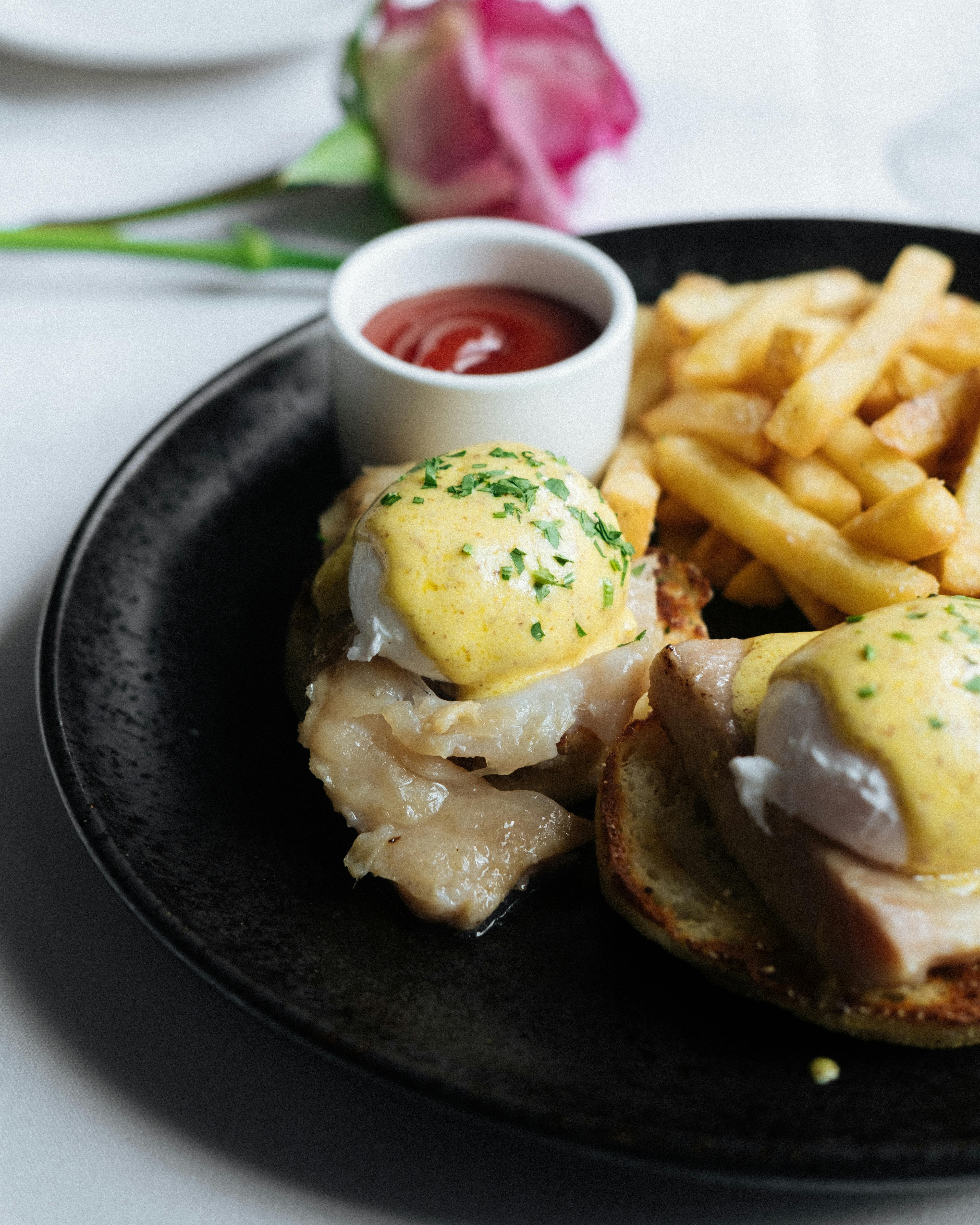 eggs benedict with french fries and salad dressing