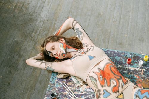 Free Artistic body paint on young woman in studio, showcasing striking colors and creative patterns. Stock Photo