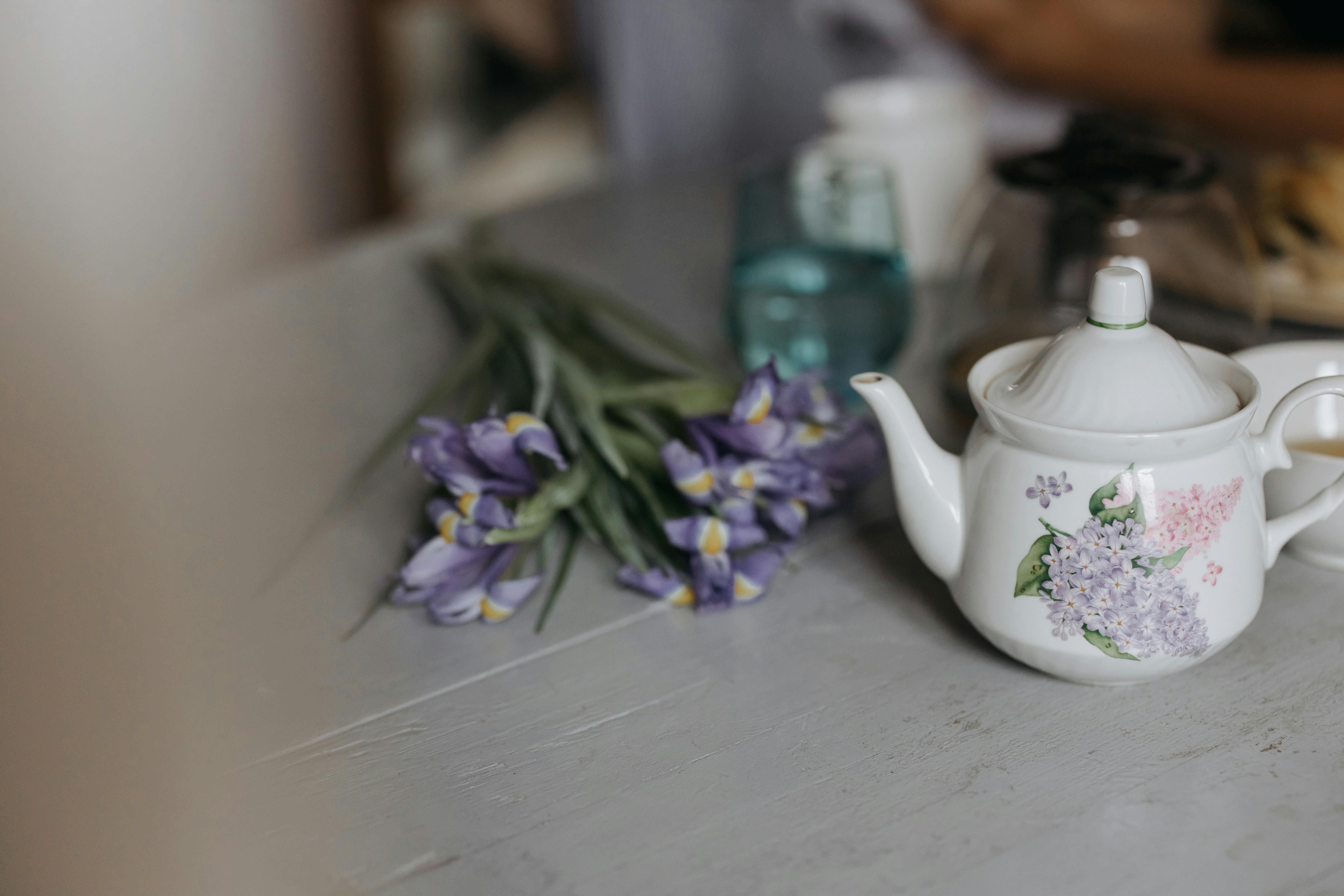 桌子上放着一个迷人的花卉茶壶，茶壶上绘有鸢尾花