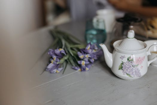 桌子上放着一个迷人的花卉茶壶，茶壶上绘有鸢尾花