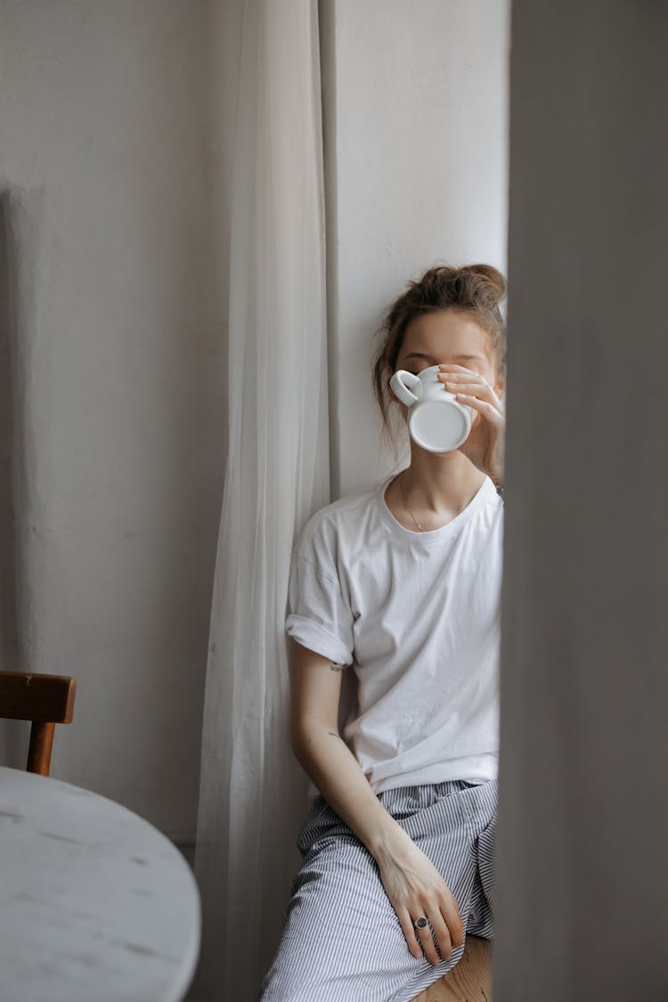 A Woman In White Shirt Drinking